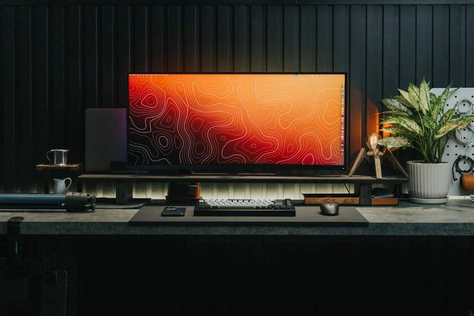 Dual monitors on a desk, showcasing web design in a modern office setting.